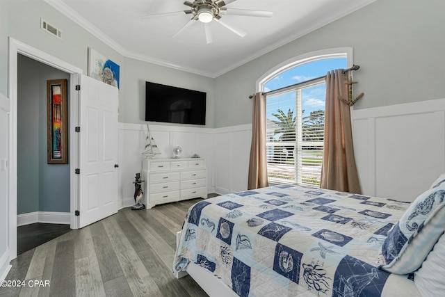 bedroom featuring ceiling fan, wood-type flooring, and crown molding