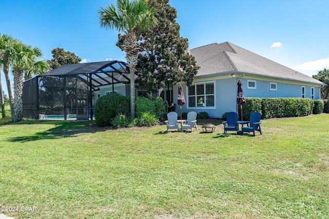 back of house with glass enclosure and a lawn