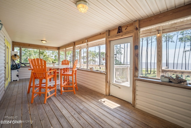 sunroom / solarium featuring a water view