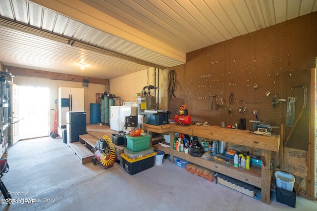 garage featuring washer / dryer, a workshop area, and gas water heater