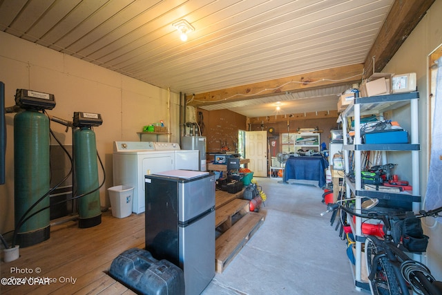 interior space with hardwood / wood-style floors, stainless steel fridge, water heater, and washing machine and clothes dryer