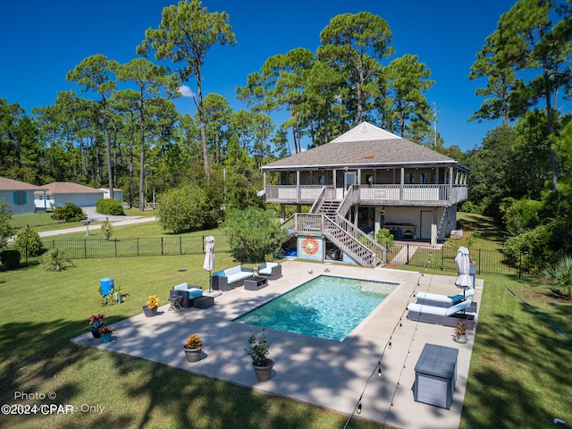 rear view of property featuring a lawn, outdoor lounge area, a swimming pool side deck, and a patio