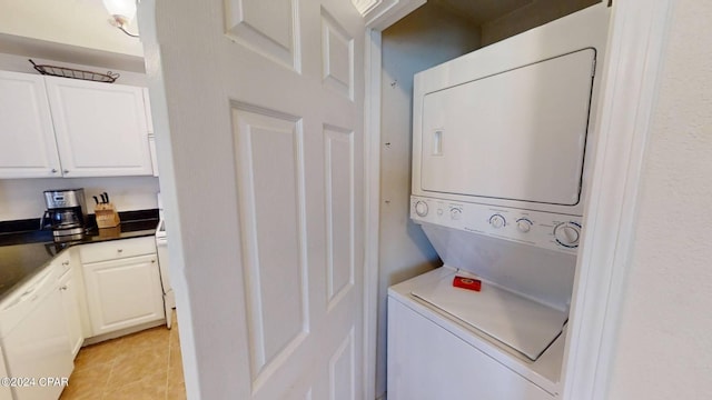 laundry room featuring stacked washer and clothes dryer and light tile patterned floors