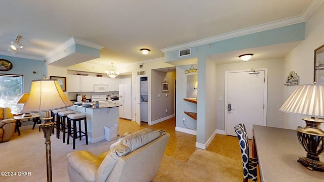 living room with a notable chandelier, crown molding, and light tile patterned flooring