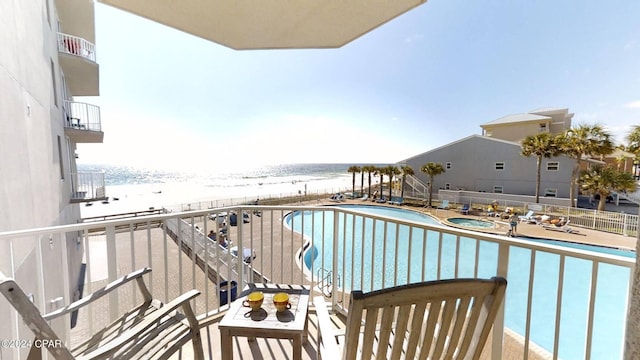 balcony with a beach view, a patio, and a water view