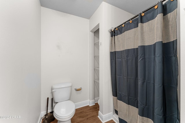 bathroom with a shower with curtain, toilet, and hardwood / wood-style floors