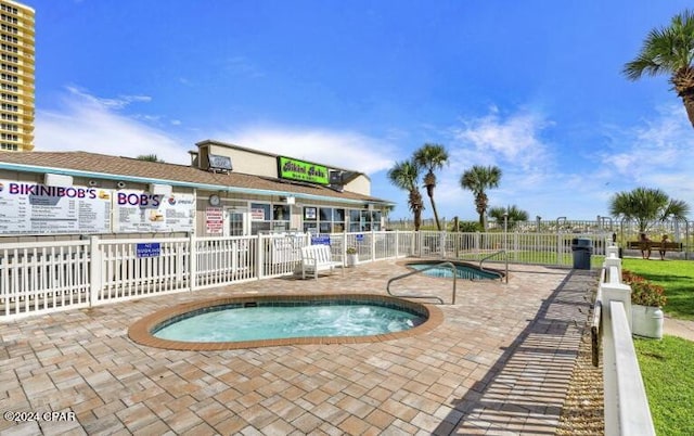 view of swimming pool featuring a community hot tub and a patio