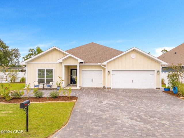 view of front of property with a front yard and a garage