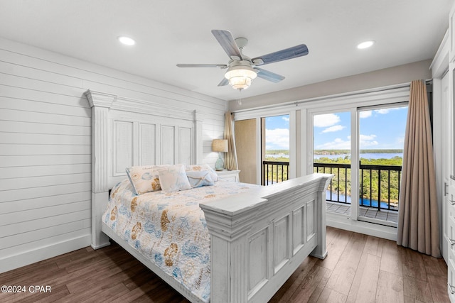 bedroom featuring access to outside, wooden walls, dark hardwood / wood-style floors, and ceiling fan