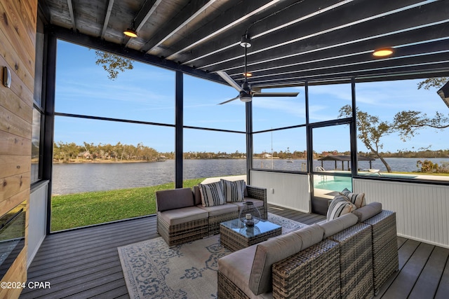 sunroom / solarium featuring ceiling fan and a water view