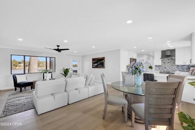 dining space with crown molding, light hardwood / wood-style flooring, and ceiling fan