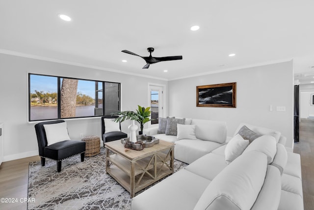 living room with hardwood / wood-style flooring, crown molding, and ceiling fan