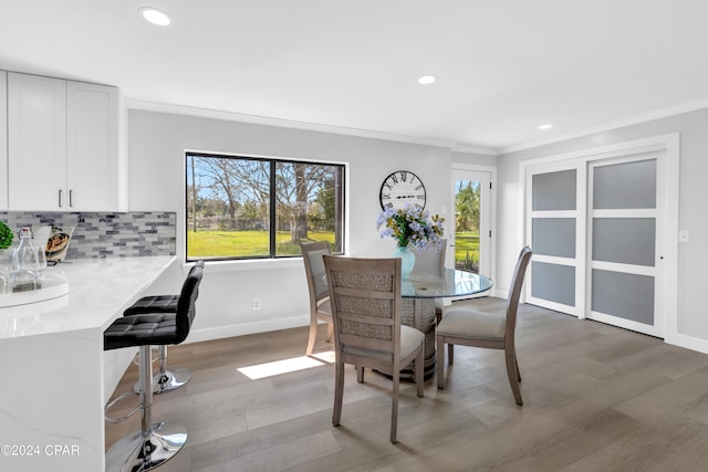 dining space featuring ornamental molding and hardwood / wood-style floors