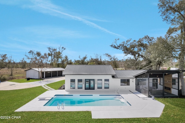 rear view of property featuring a yard, a sunroom, and a patio