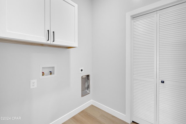 laundry room featuring electric dryer hookup, washer hookup, light wood-type flooring, and cabinets