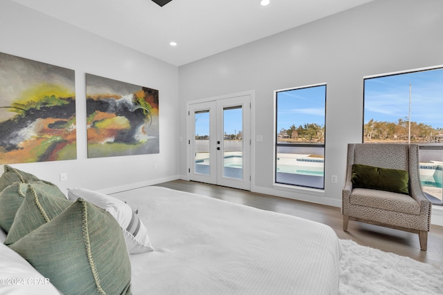 bedroom with access to exterior, hardwood / wood-style floors, and french doors