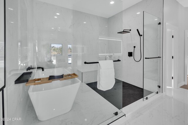 bathroom with shower with separate bathtub and tile walls