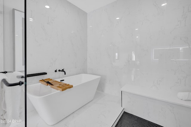 bathroom with a bathing tub and tile walls