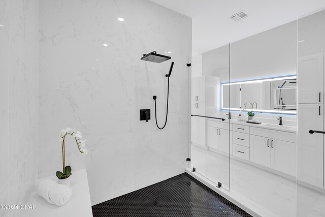 bathroom featuring a tile shower and vanity