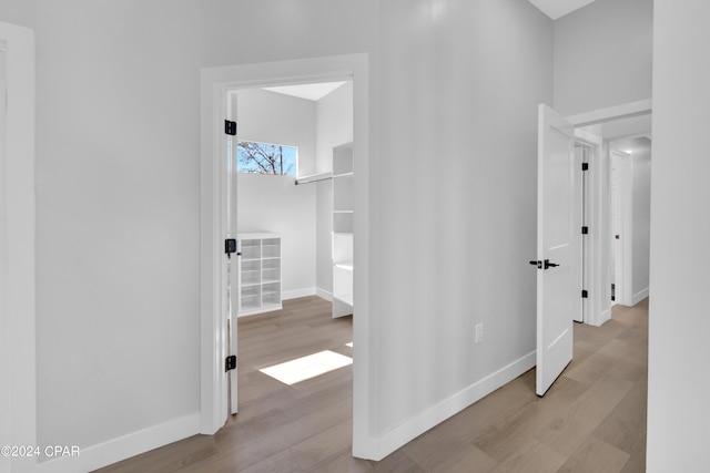 hallway with light hardwood / wood-style floors