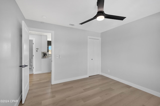 unfurnished bedroom featuring a closet, light hardwood / wood-style flooring, and ceiling fan