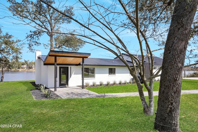 view of front of home featuring a front yard and a water view