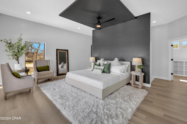 bedroom with ceiling fan, light wood-type flooring, and multiple windows