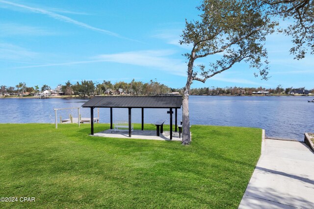 view of dock featuring a gazebo, a water view, and a lawn