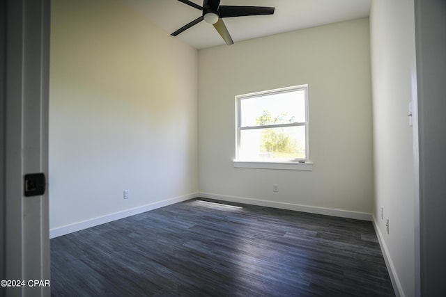 unfurnished room with dark wood-type flooring, a ceiling fan, and baseboards
