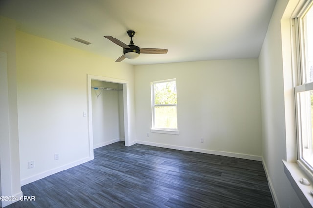 unfurnished bedroom with dark wood-style floors, a closet, a ceiling fan, visible vents, and baseboards