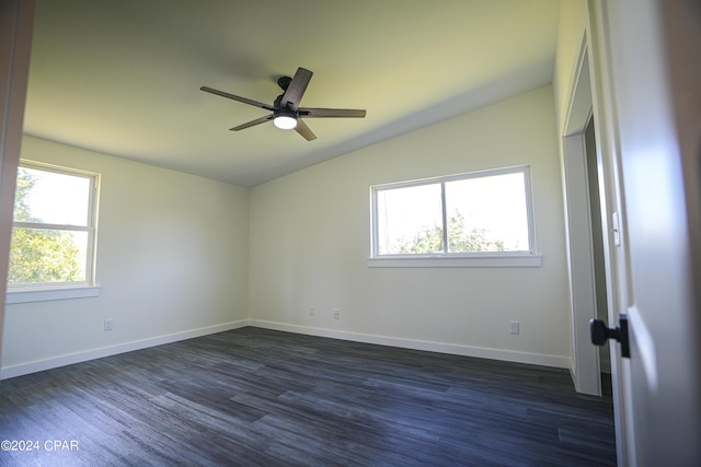 empty room featuring lofted ceiling, ceiling fan, plenty of natural light, and dark wood finished floors