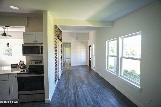 kitchen with light countertops, dark wood-style flooring, stainless steel appliances, and baseboards