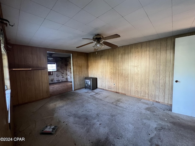 unfurnished living room featuring wooden walls and carpet