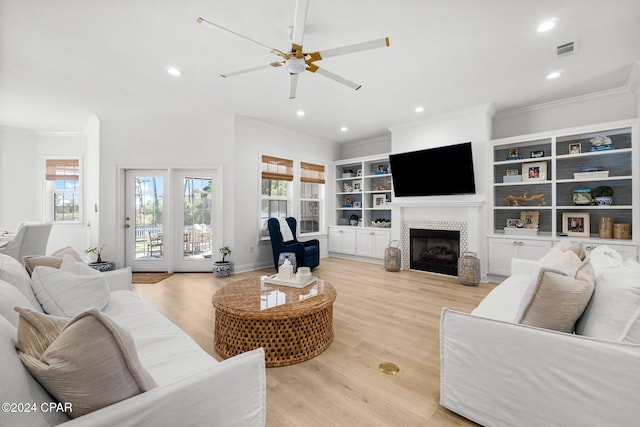 living room featuring a fireplace, crown molding, and light hardwood / wood-style floors