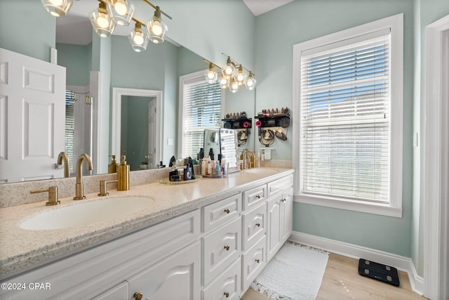 bathroom featuring a chandelier, hardwood / wood-style floors, vanity, and a wealth of natural light