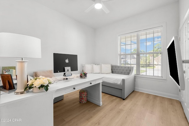 office area featuring built in desk, light wood-type flooring, and ceiling fan