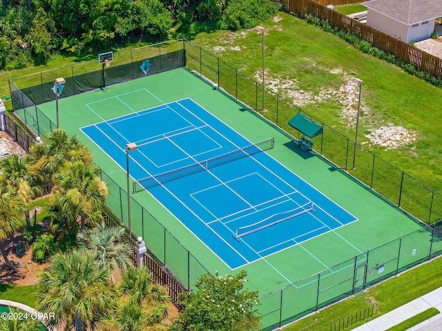 view of tennis court featuring a lawn