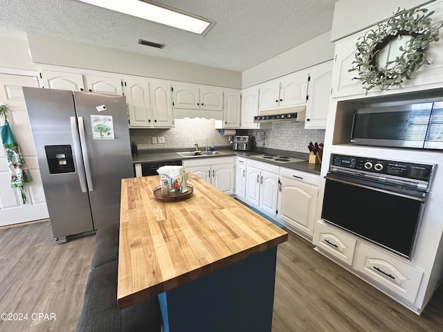 kitchen featuring a textured ceiling, dark hardwood / wood-style floors, stainless steel appliances, and white cabinets