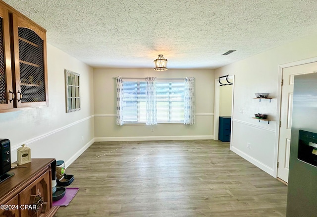 dining space featuring hardwood / wood-style floors and a textured ceiling