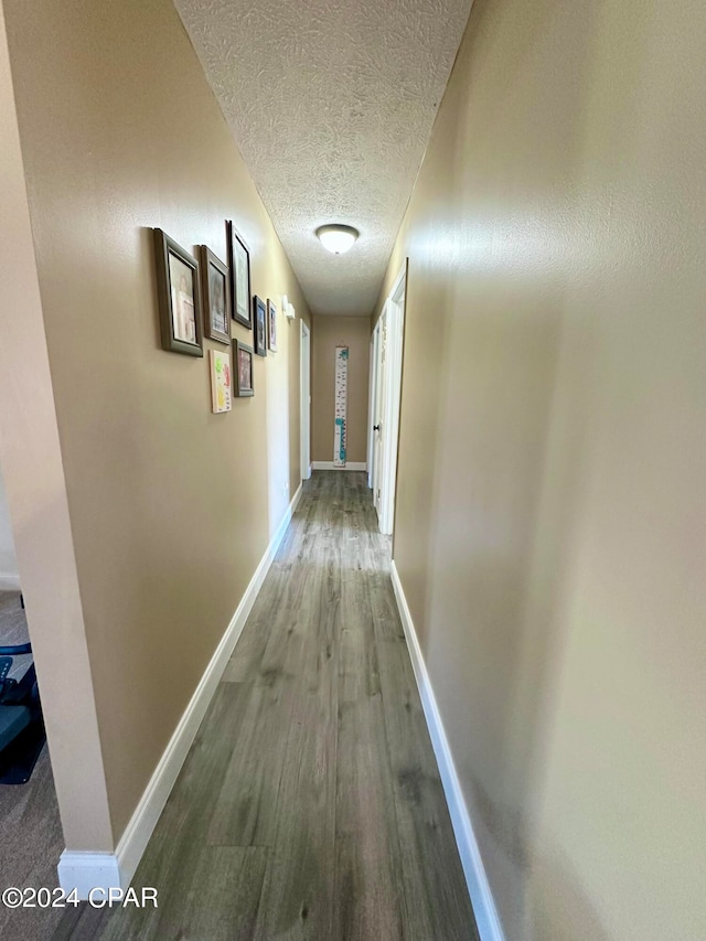 hallway featuring hardwood / wood-style floors and a textured ceiling