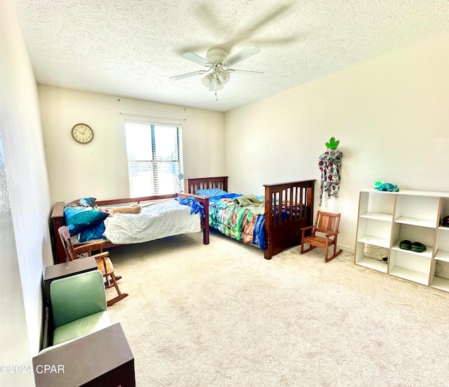 carpeted bedroom featuring a textured ceiling and ceiling fan