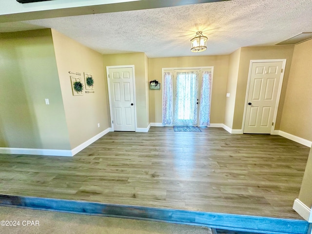 entryway with wood-type flooring and a textured ceiling