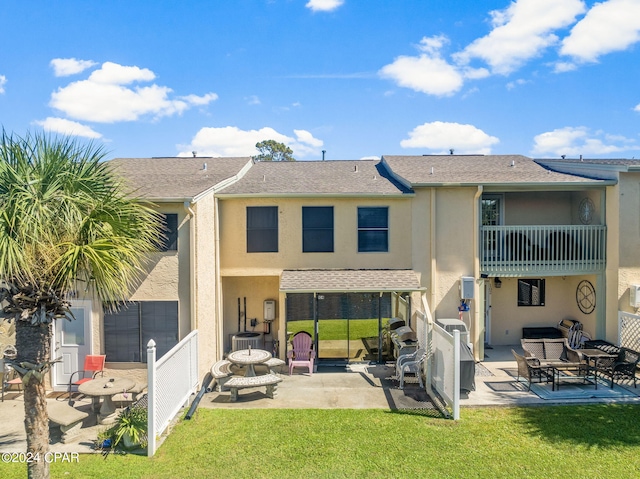 rear view of property with a yard and a patio