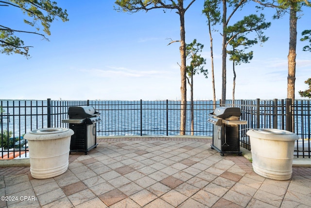 view of patio / terrace featuring area for grilling and a water view