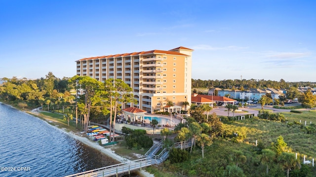 view of building exterior with a community pool and a water view