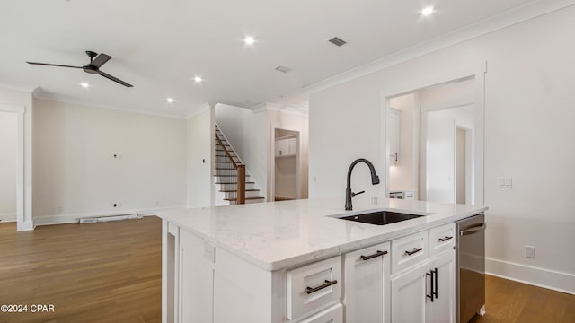 kitchen with crown molding, dark hardwood / wood-style flooring, a center island with sink, sink, and white cabinetry