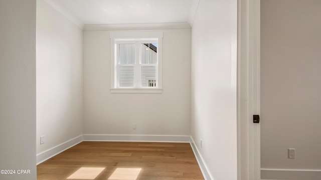 unfurnished room with light hardwood / wood-style floors and crown molding