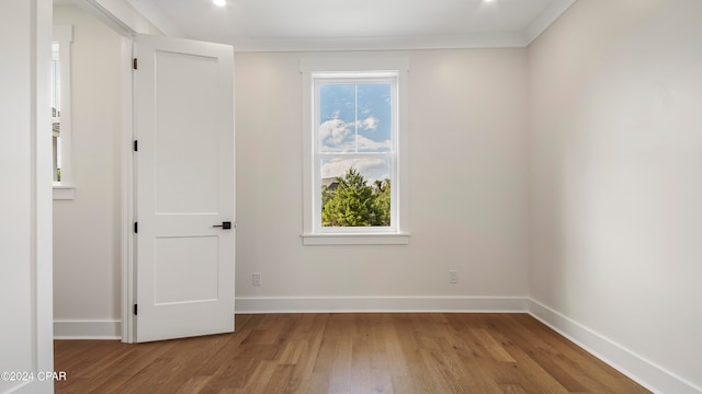 unfurnished room with ornamental molding and light wood-type flooring