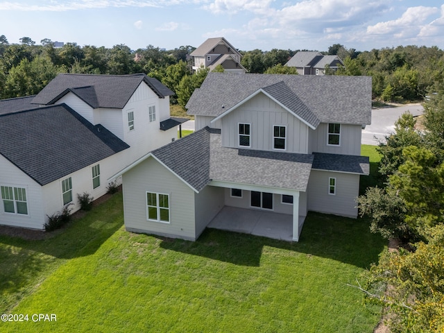 back of property with a lawn and a patio