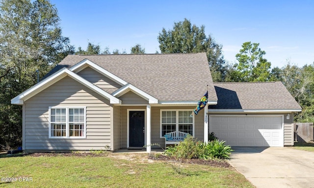 view of front of property featuring a garage, a front lawn, and a porch